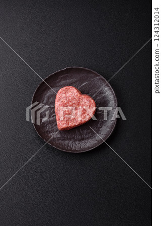 Raw beef or pork burger patty in the shape of a heart 124312014