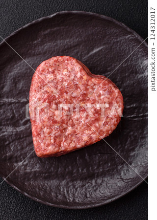 Raw beef or pork burger patty in the shape of a heart Raw beef or pork burger patty in the shape of a heart 124312017