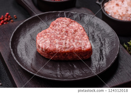 Raw beef or pork burger patty in the shape of a heart Raw beef or pork burger patty in the shape of a heart 124312018