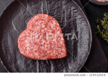 Raw beef or pork burger patty in the shape of a heart 124312019