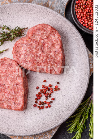 Raw beef or pork burger patty in the shape of a heart 124312032