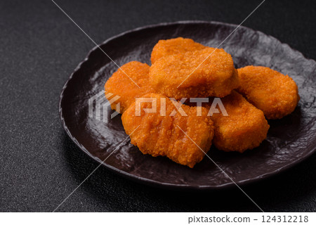 Delicious fresh crispy chicken nuggets on a dark concrete background 124312218