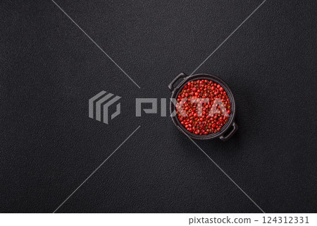 Spice, allspice peas in red or pink color in a bowl on a black concrete background 124312331