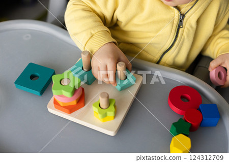 Baby with educational toy, Cognitive skills, Montessori activity. Closeup, selective focus. Baby with educational toy, Cognitive skills, Montessori activity. Closeup, selective focus. 124312709