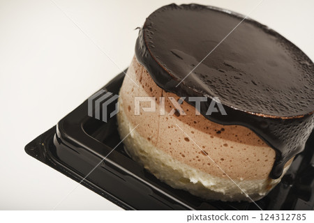 Coffee and milk cheesecake. A cake with cheese and chocolate on a plate. 124312785