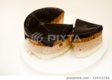 Coffee and milk cheesecake. A cake with cheese and chocolate on a plate. 124312788