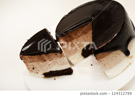 Coffee and milk cheesecake. A cake with cheese and chocolate on a plate. 124312789