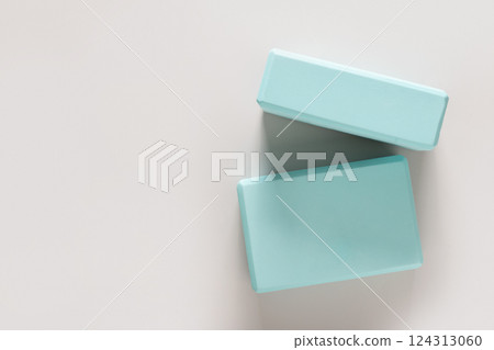 Green yoga blocks on gray background. Yoga practice, relaxation and meditation concept. Top view with copy space. Green yoga blocks on gray background. Yoga practice, relaxation and meditation concept. Top view with copy space. 124313060