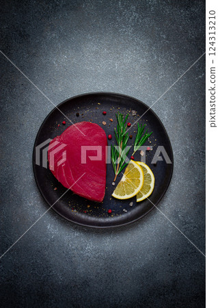fresh red tuna fillet, for steak, raw, top view, on a black plate , no people, fresh red tuna fillet, for steak, raw, top view, on a black plate , no people, 124313210