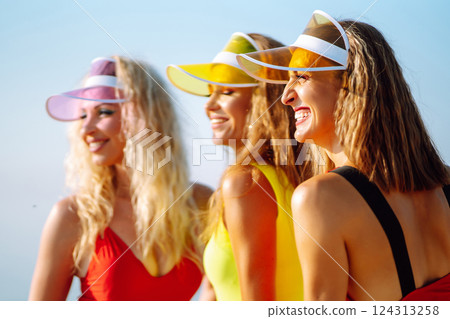 Smiling dancers in colorful swimsuits are dancing on beach ?oncept of sports, aerobics. Active sport 124313258
