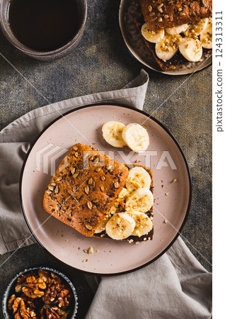Toast rye bread with chocolate and banana on a plate on the table top and vertical view Toast rye bread with chocolate and banana on a plate on the table top and vertical view 124313311