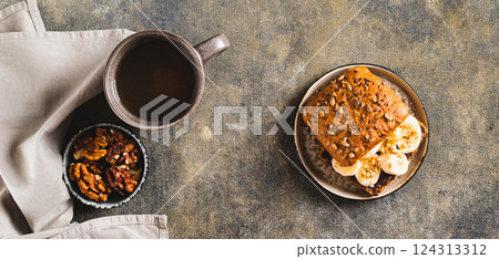 Toast rye bread with chocolate and banana on a plate on the table top view web banner 124313312
