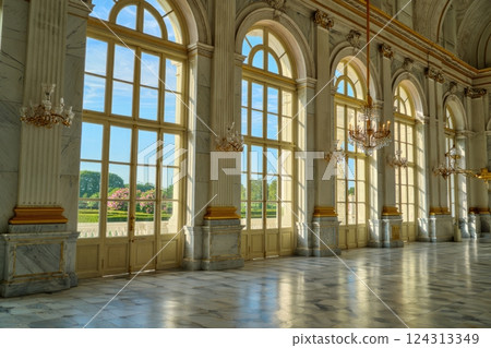 Grand hall with large windows in palace or castle, surrounded by lush greenery 124313349