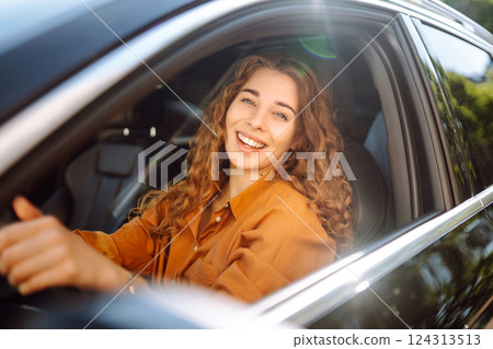 Stylish woman driving car. Traveler is the driver. Automobile travel. Sharing car. Lifestyle concept 124313513
