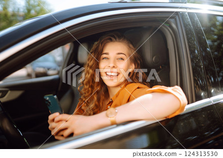 The driver of the car uses a smartphone. Leisure, travel, technology, navigation. 124313530