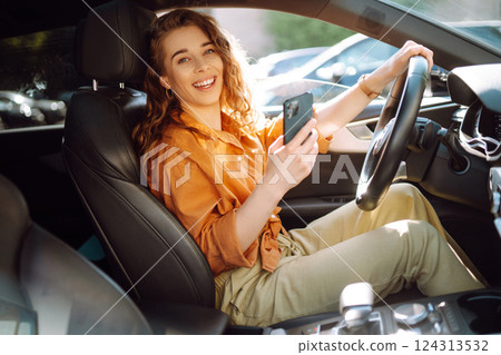 The driver of the car uses a smartphone. Leisure, travel, technology, navigation. 124313532
