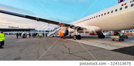 Passengers Boarding an Airplane at Airport 124313670