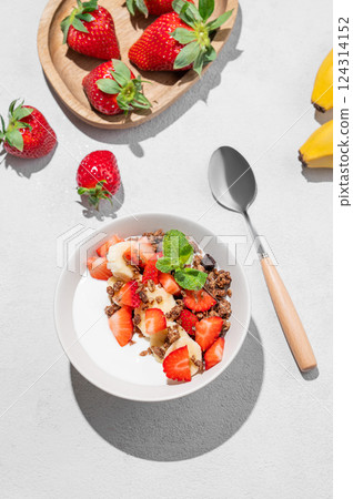 Natural Greek yogurt with homemade chocolate granola, strawberries and banana in a bowl Natural Greek yogurt with homemade chocolate granola, strawberries and banana in a bowl 124314152