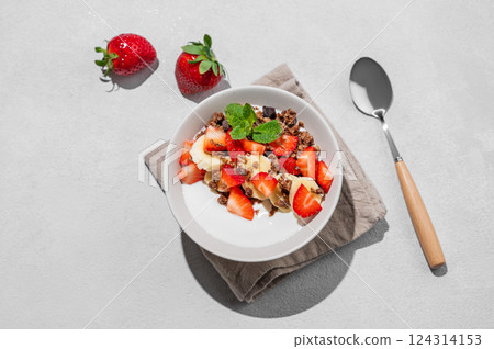 Greek yogurt with homemade chocolate granola, strawberries and banana in a bowl Greek yogurt with homemade chocolate granola, strawberries and banana in a bowl 124314153