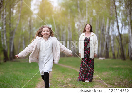 Mom and daughter are walking in the park. 124314280