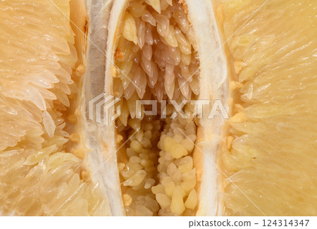 Detailed close-up of a fresh pomelo fruit, showing the juicy flesh, seeds, and fibrous texture. Natural, organic tropical citrus fruit in macro view. Detailed close-up of a fresh pomelo fruit, showing the juicy flesh, seeds, and fibrous texture. Natural, organic tropical citrus fruit in macro view. 124314347