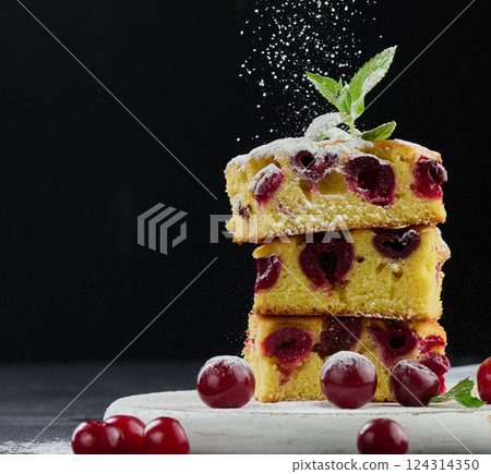 Stack of baked cherry pie sprinkled with powdered sugar on black background Stack of baked cherry pie sprinkled with powdered sugar on black background 124314350