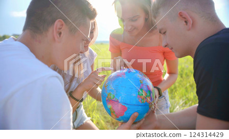 Friends are examining the globe of the earth. 124314429
