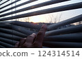 Staying at home, quarantine, looking at a sunset through the blinds background 124314514
