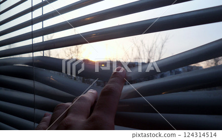 Staying at home, quarantine, looking at a sunset through the blinds background Staying at home, quarantine, looking at a sunset through the blinds background 124314514