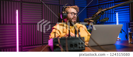 Banner Young smiling male radio presenter talking into the microphone and reading news, information and communication concept. Podcast and internet streaming concept. 124315080