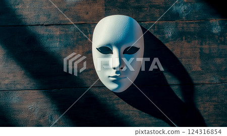 White mask casting dramatic shadow on wooden surface 124316854