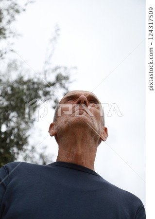 Elderly Man Looks Around Suspiciously In The Park 124317509