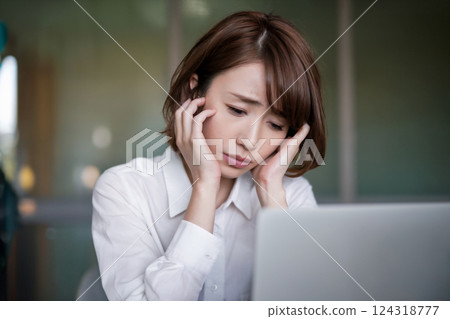A woman looking at a computer screen and worrying Generative AI 124318777