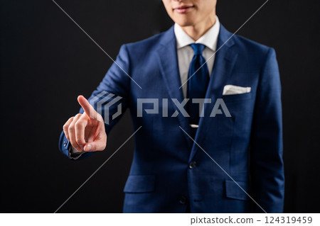 Businessman pointing with index finger - black background Businessman pointing with index finger - black background 124319459