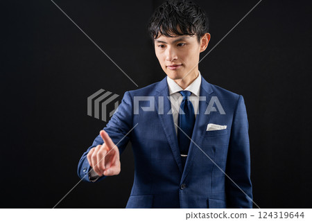 Businessman pointing with index finger, man, black background 124319644