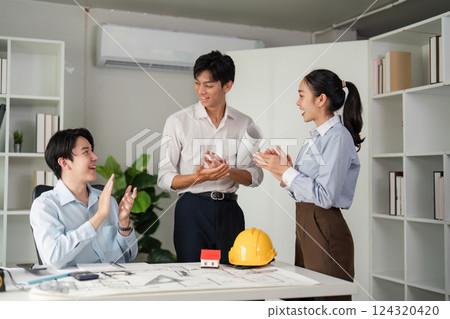 Collaboration and Achievement. Celebrating a successful project milestone with teamwork and creativity in the office. 124320420