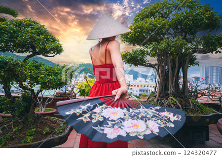 back of female tourist traveler in Vietnamese non la hat and fan is traveling in Vietnam in Asia 124320477