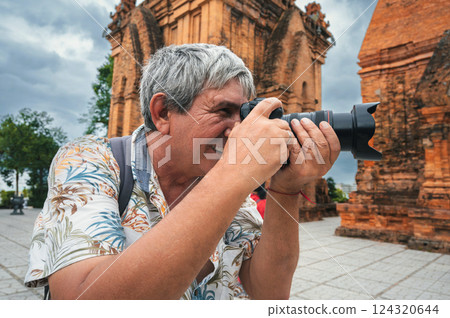 happy elderly man tourist traveling photographer with a camera takes pictures of landmarks at Po Nagar Cham Towers in Nha Trang in Vietnam in Asia happy elderly man tourist traveling photographer with a camera takes pictures of landmarks at Po Nagar Cham Towers in Nha Trang in Vietnam in Asia 124320644