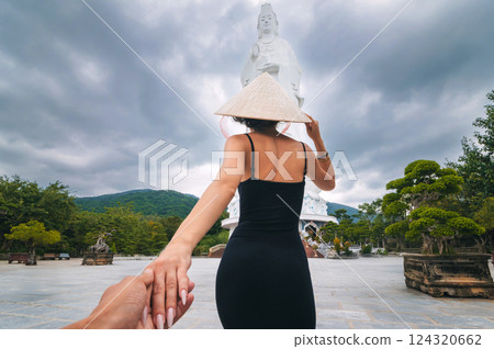back of girl tourist traveler at Lady Buddha statue at Linh Ung Pagoda in Da Nang in Vietnam. Follow me concept of travel and tourism in Asia 124320662