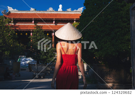 back of a Vietnamese tourist woman in Non La hat at a pagoda temple in Vietnam on trip to Asia back of a Vietnamese tourist woman in Non La hat at a pagoda temple in Vietnam on trip to Asia 124320682