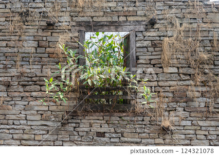 The rock wall of an abandoned house in rural area of Nepal. Traditional house in local Nepal normally made by rock and stone. The rock wall of an abandoned house in rural area of Nepal. Traditional house in local Nepal normally made by rock and stone. 124321078