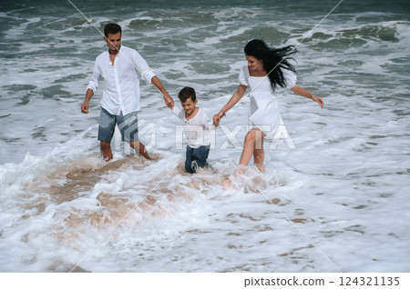 happy family parents with a child boy son playing on beach in the sea on summer vacation happy family parents with a child boy son playing on beach in the sea on summer vacation 124321135