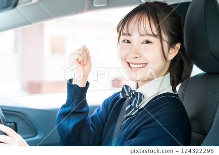 A high school girl pumps her fist in excitement after getting her regular driver's license A high school girl pumps her fist in excitement after getting her regular driver's license 124322298