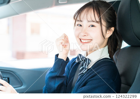 A high school girl pumps her fist in excitement after getting her regular driver's license A high school girl pumps her fist in excitement after getting her regular driver's license 124322299
