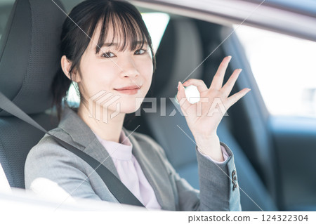 A young woman in a suit in a car making an OK pose A young woman in a suit in a car making an OK pose 124322304