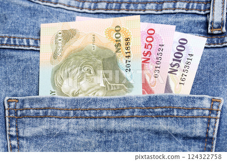 Old Uruguayan peso in the pocket of blue jeans 124322758