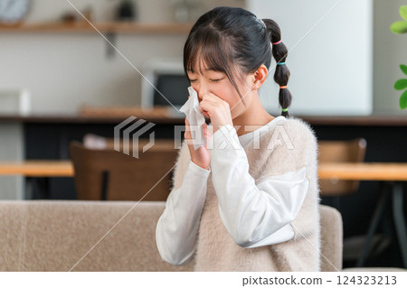 Girl blowing her nose during hay fever season (allergies, allergic rhinitis, rhinitis) 124323213