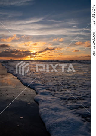 A Stunning Sunset Paints the Sky Over the Calm Ocean Waves Creating a Breathtaking Scene A Stunning Sunset Paints the Sky Over the Calm Ocean Waves Creating a Breathtaking Scene 124323273