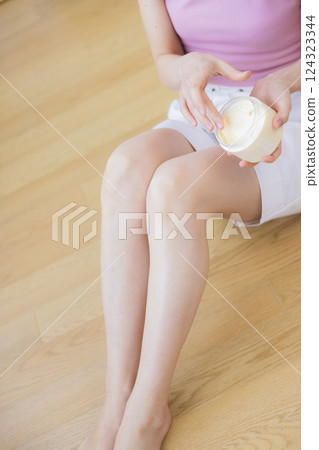 Part cut: A woman applying cream to her legs 124323344