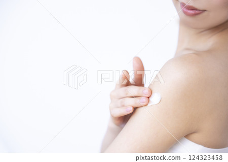 Part cut: A woman applying cream to her arm 124323458